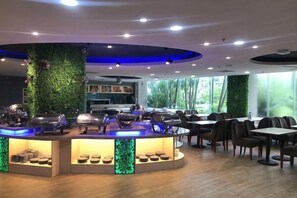 A restaurant with a central bar, seating area, and large windows. - Zhanjiang Zhongtailai Hotel (Yifu International Plaza Branch) (Zhanjiang)