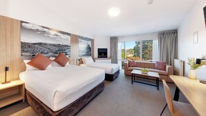 Une chambre d’hôtel avec un grand lit, un canapé, un bureau et une télévision.
