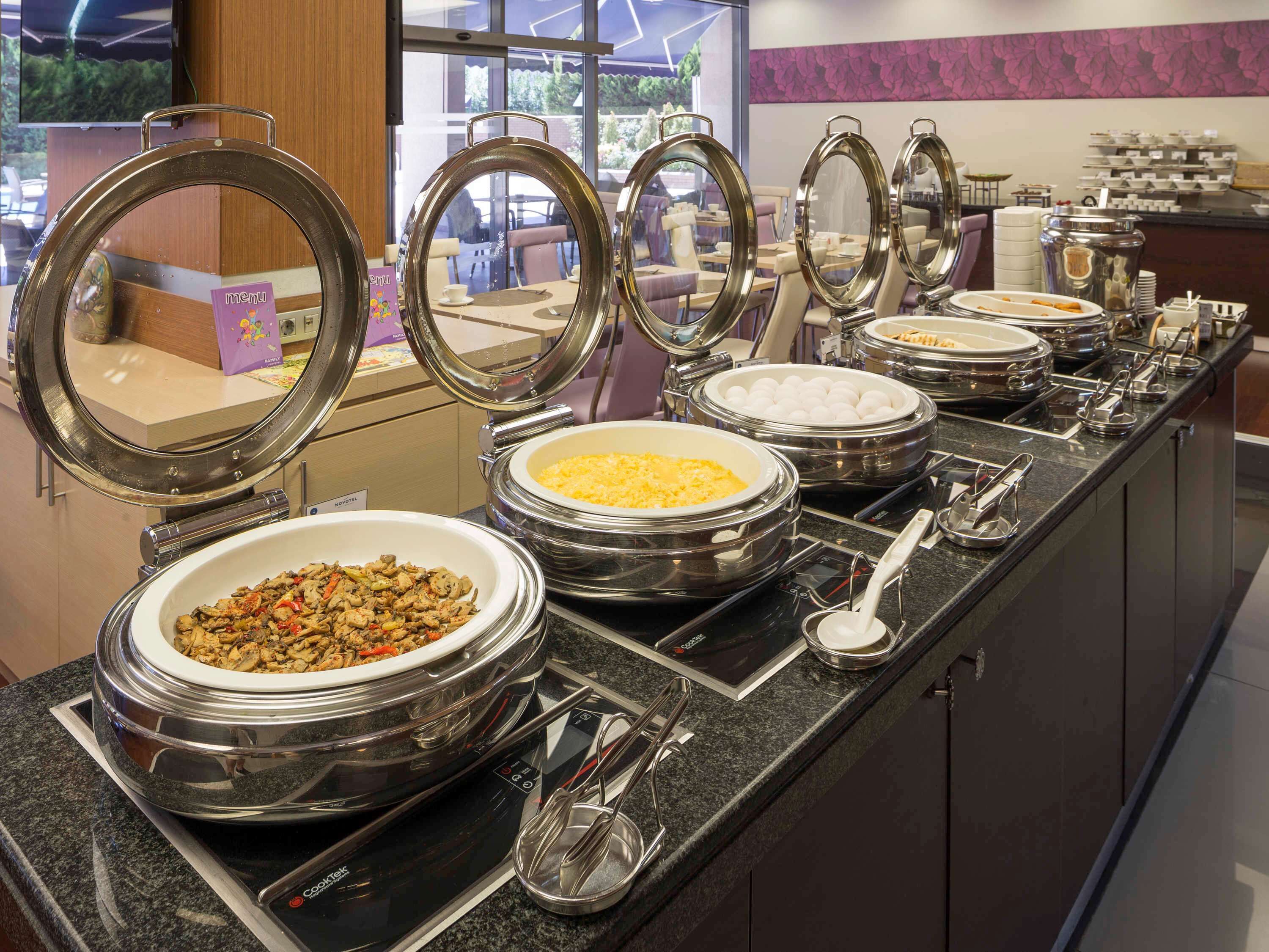 A buffet setup with multiple self-service bowls and utensils.