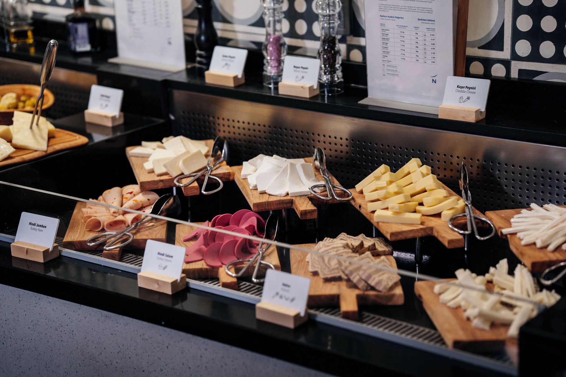 A cheese and ham display with labels.