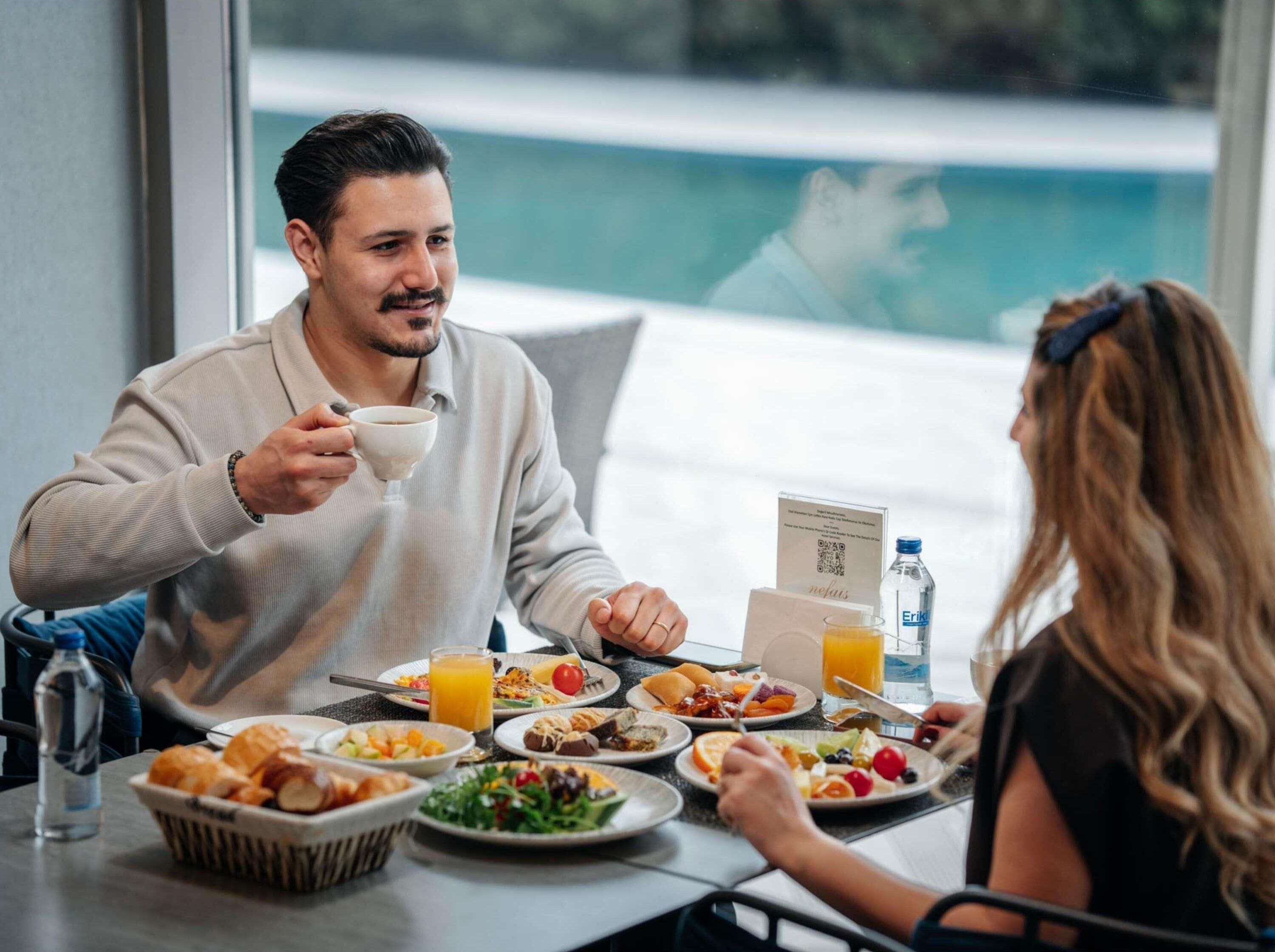 A dining table with breakfast items, a water bottle, and a menu.