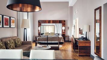 Una habitación de hotel moderna con cama, escritorio, zona de comedor y sala de estar.