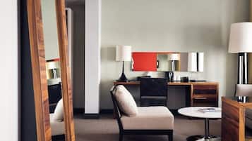 Een hotelkamer met een bed, een bureau, een stoel, een ronde tafel en een spiegel.