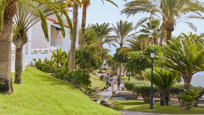 A pathway lined with palm trees and a building with balconies. - TUI MAGIC LIFE Fuerteventura (Pajara)