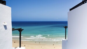A beach view from a white building with a clear blue sky. - TUI MAGIC LIFE Fuerteventura (Pajara)