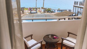 A balcony with wicker furniture, a small round table, and a view of the ocean. - TUI MAGIC LIFE Fuerteventura (Pajara)
