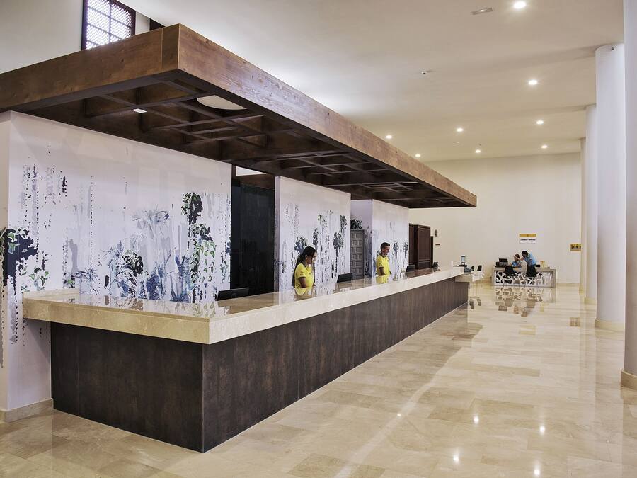A reception area with a long counter, wooden ceiling beams, and a tiled floor.