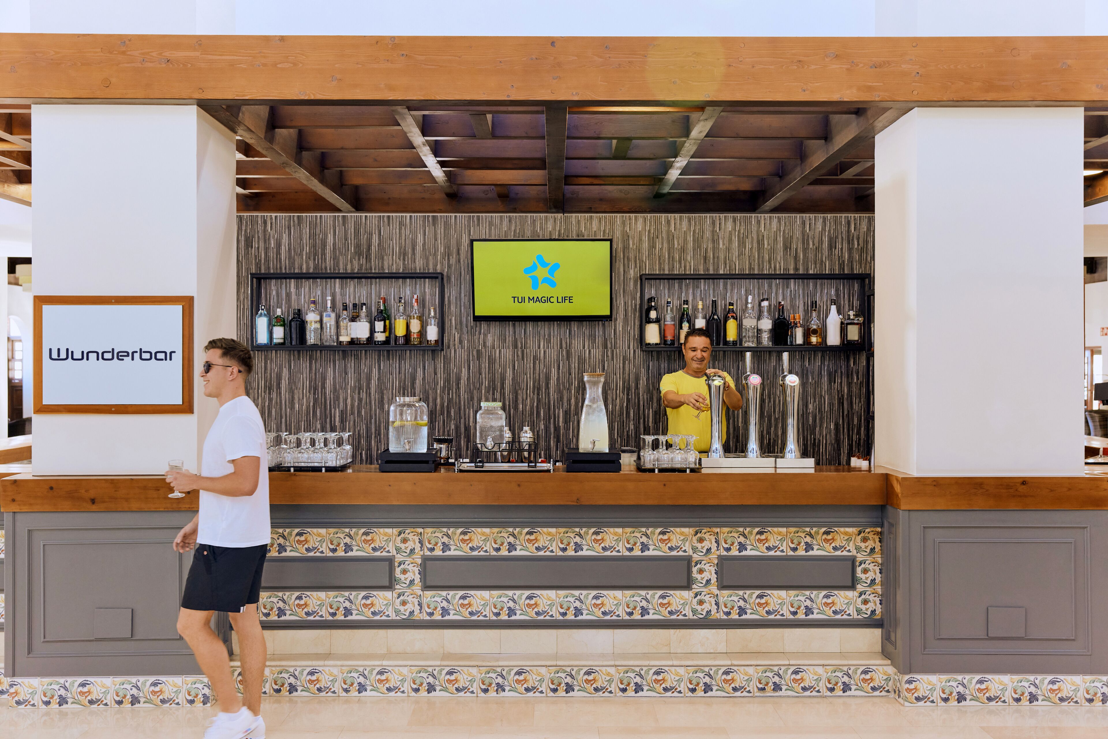 A bar area with a wooden ceiling, a tiled floor, and a sign reading "Wunderbar".