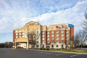 Een Fairfield by Marriott hotel met een bakstenen gevel, meerdere ramen en een parkeerplaats.