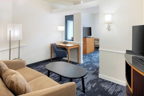 A hotel room with a sofa, a desk, a television, and a lamp. - Fairfield Inn & Suites Columbus Polaris (Columbus)