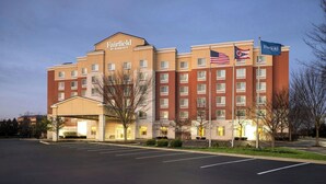 Un hôtel Fairfield by Marriott avec une façade en briques, de nombreuses fenêtres et un parking.