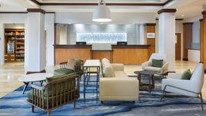 A lobby with a reception desk, seating area, and a view of the outside through a window. - Fairfield Inn & Suites Columbus Polaris (Columbus)