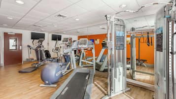 Uma academia com esteiras, elípticos e equipamentos de musculação.