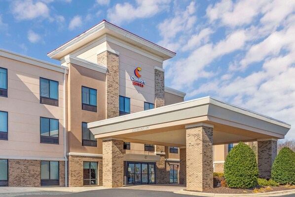 A Comfort Suites hotel with a covered entrance, clear signage, and a brick facade.