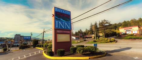 Señal de Bay City Inn en una intersección de caminos, con cielo despejado.