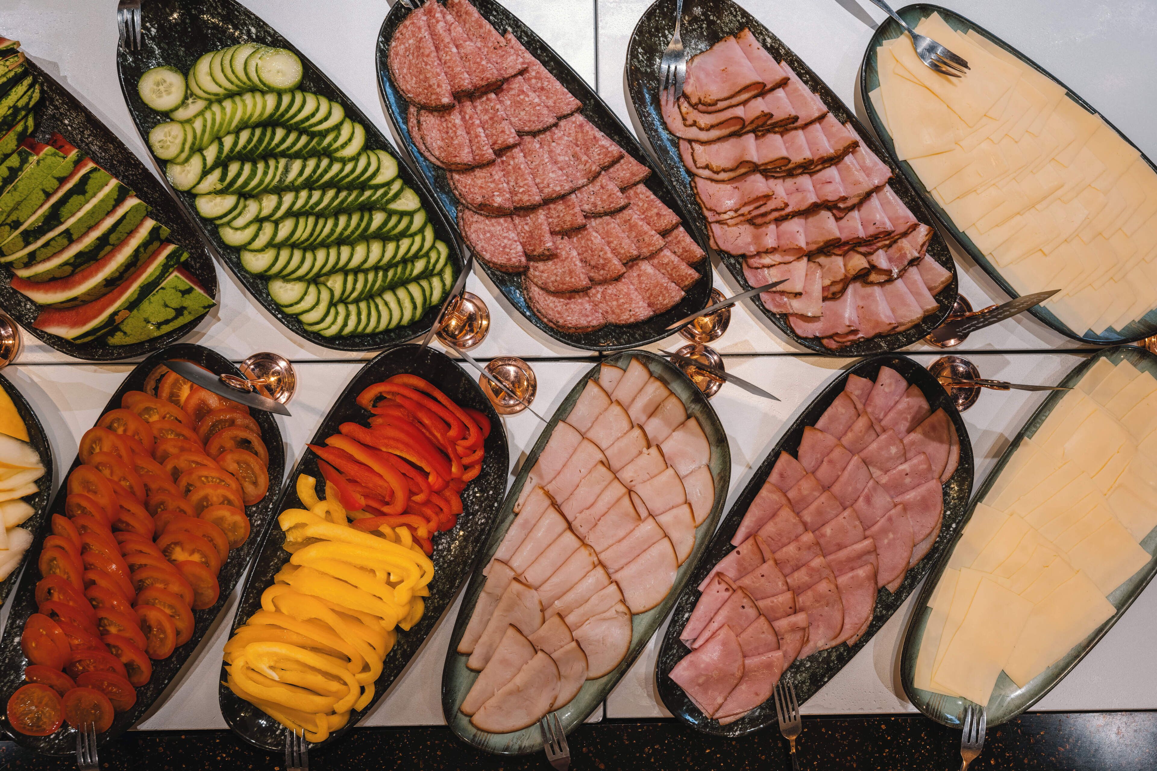 Un bufé con diversos alimentos dispuestos en bandejas.