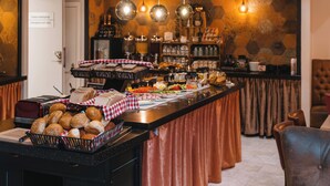 Montaje de bufé con distintos alimentos, un mantel a cuadros y lámparas colgantes.