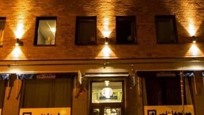 Un edificio de varios pisos con ventanas iluminadas y escaparate.