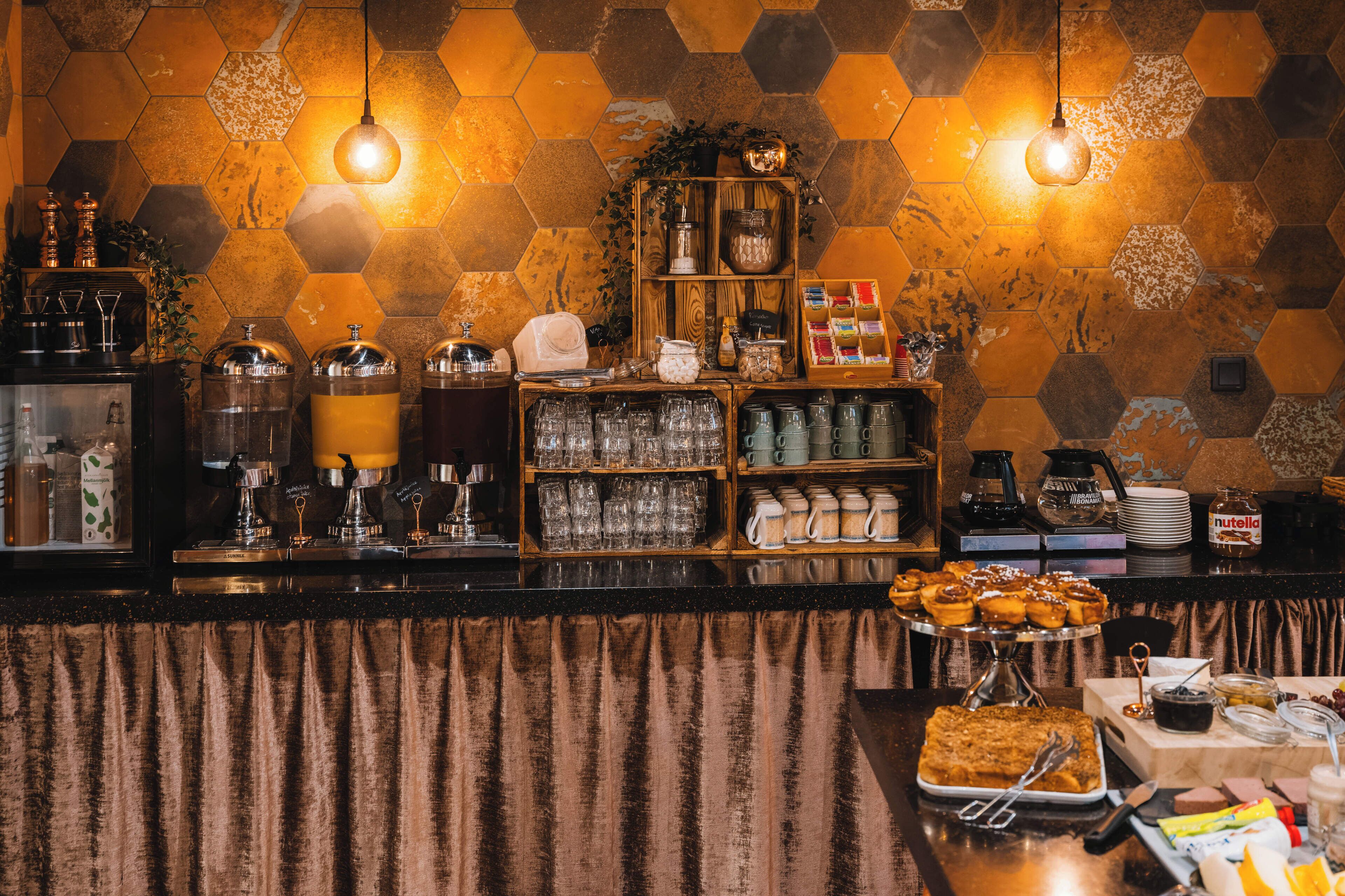 Een ontbijtbuffet met diverse soorten eten, drinkglazen en keukengerei.