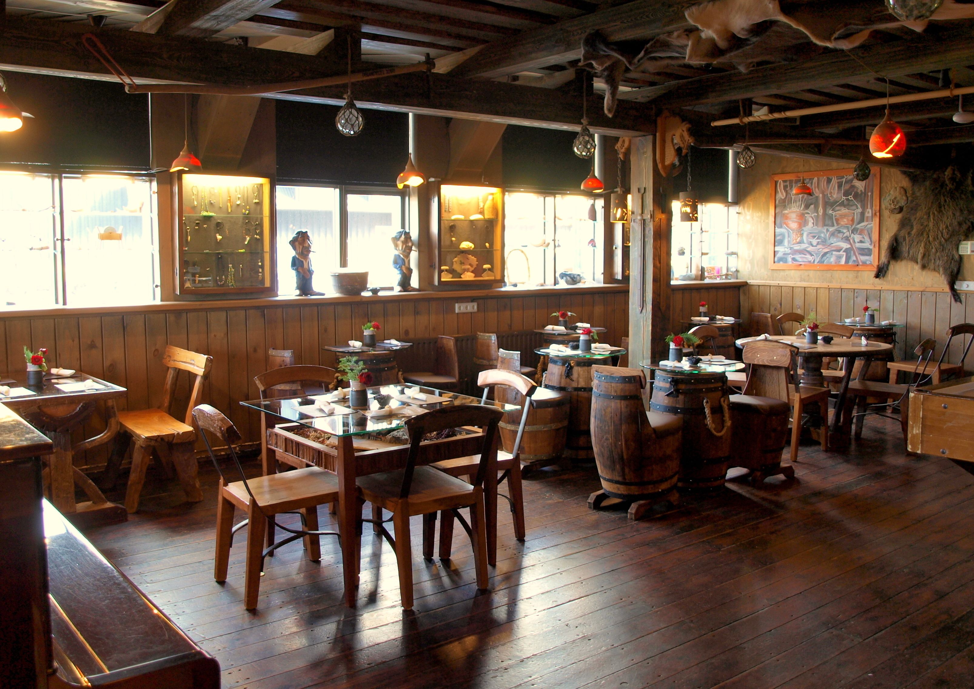 L’intérieur de ce restaurant rustique est agrémenté de meubles en bois, de luminaires suspendus et d’une fresque murale.