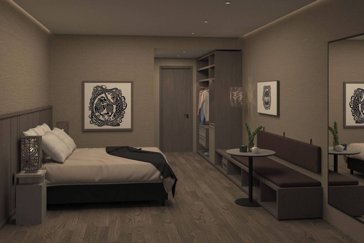 A modern bedroom with a bed, bedside table, and a small seating area with a table and bench.