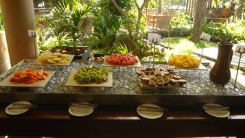Un buffet proposant une variété de fruits et de légumes, disposés sur un comptoir en marbre.