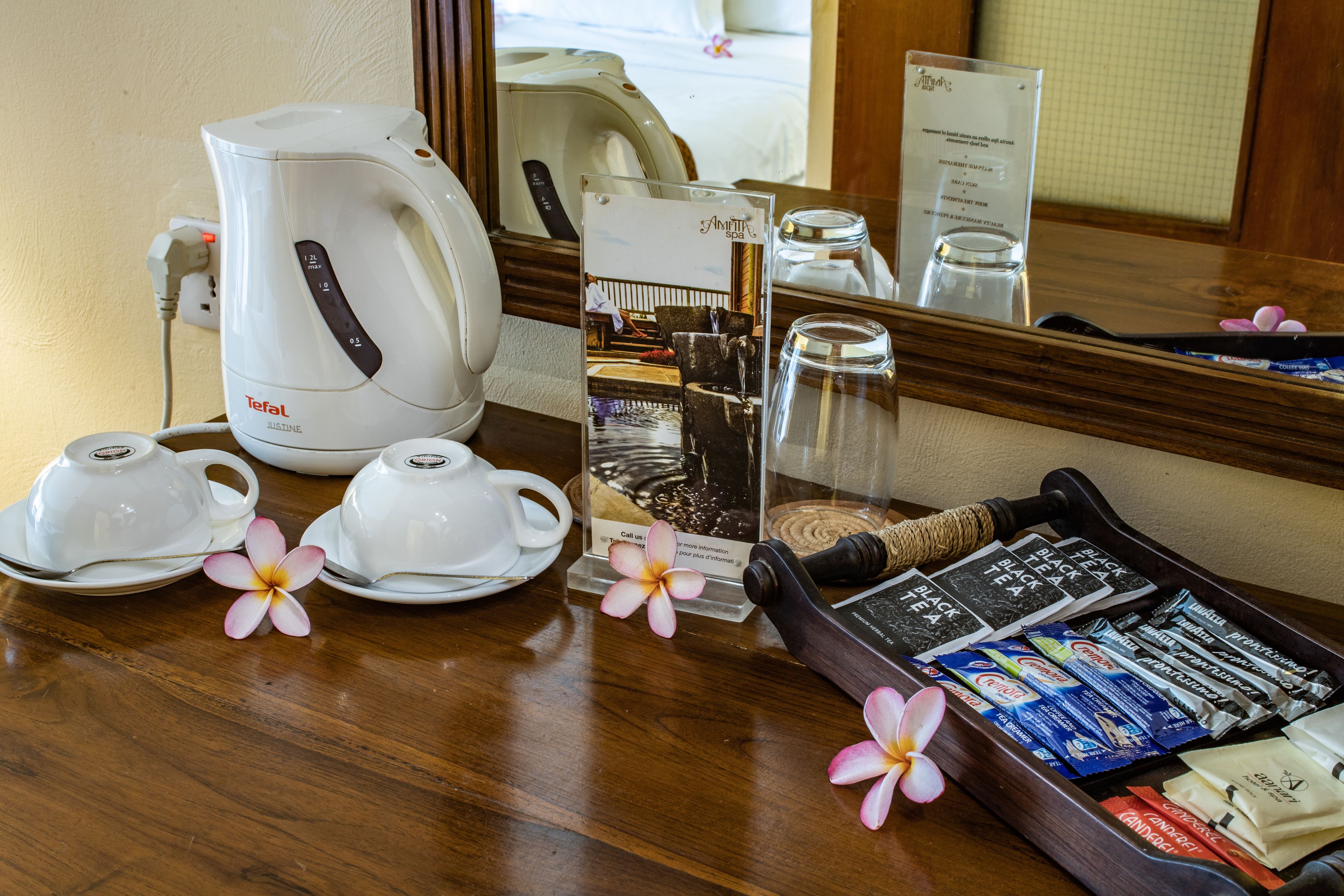 Ontbijt in een hotelkamer, met een koffiezetapparaat, theepotten, een dienblad met theezakjes en een menukaart.