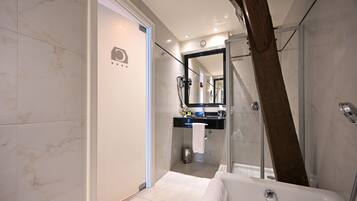 A modern bathroom with a glass shower enclosure, a bathtub, and a vanity with a mirror.