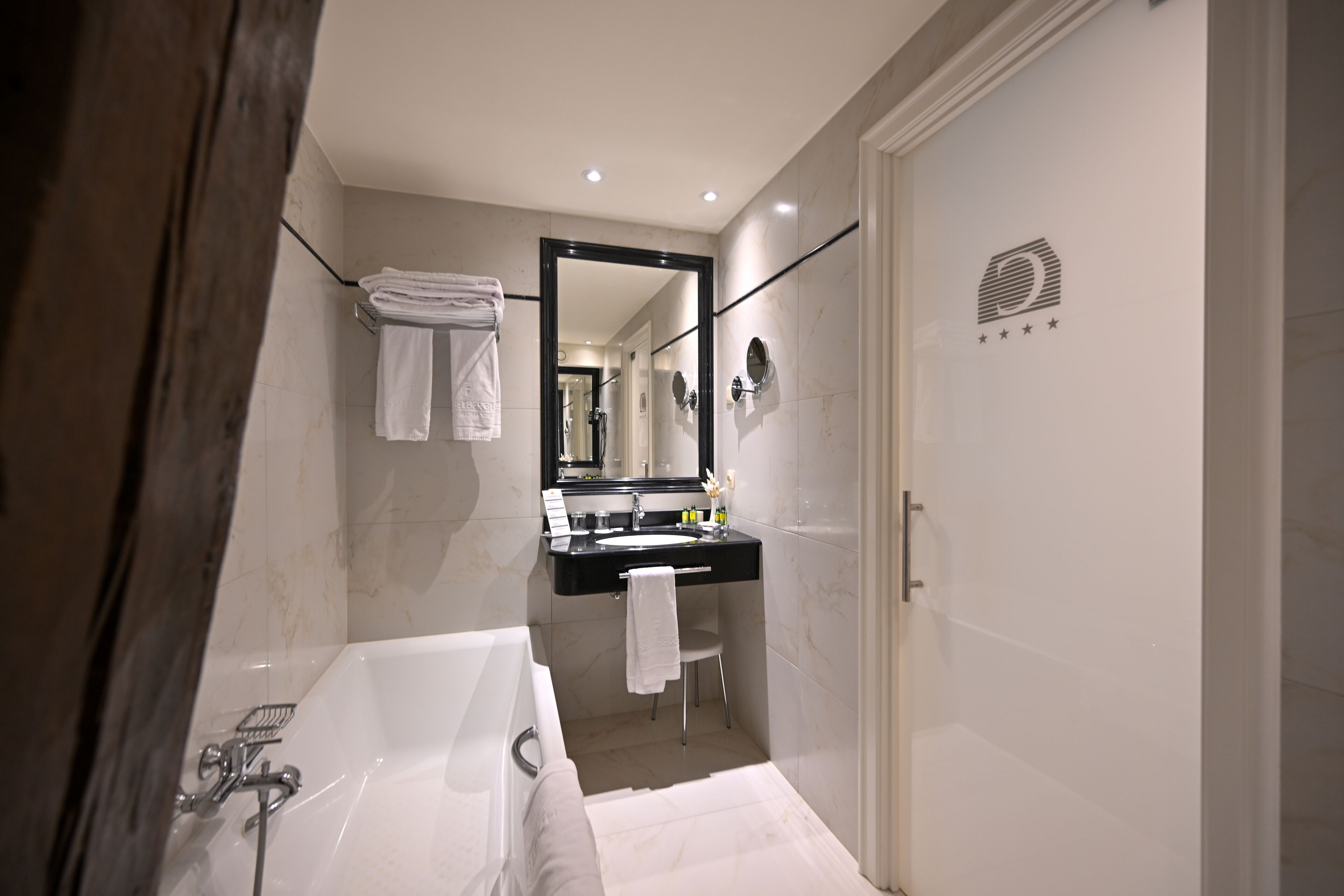 A modern bathroom with a bathtub, a sink, and a mirror.