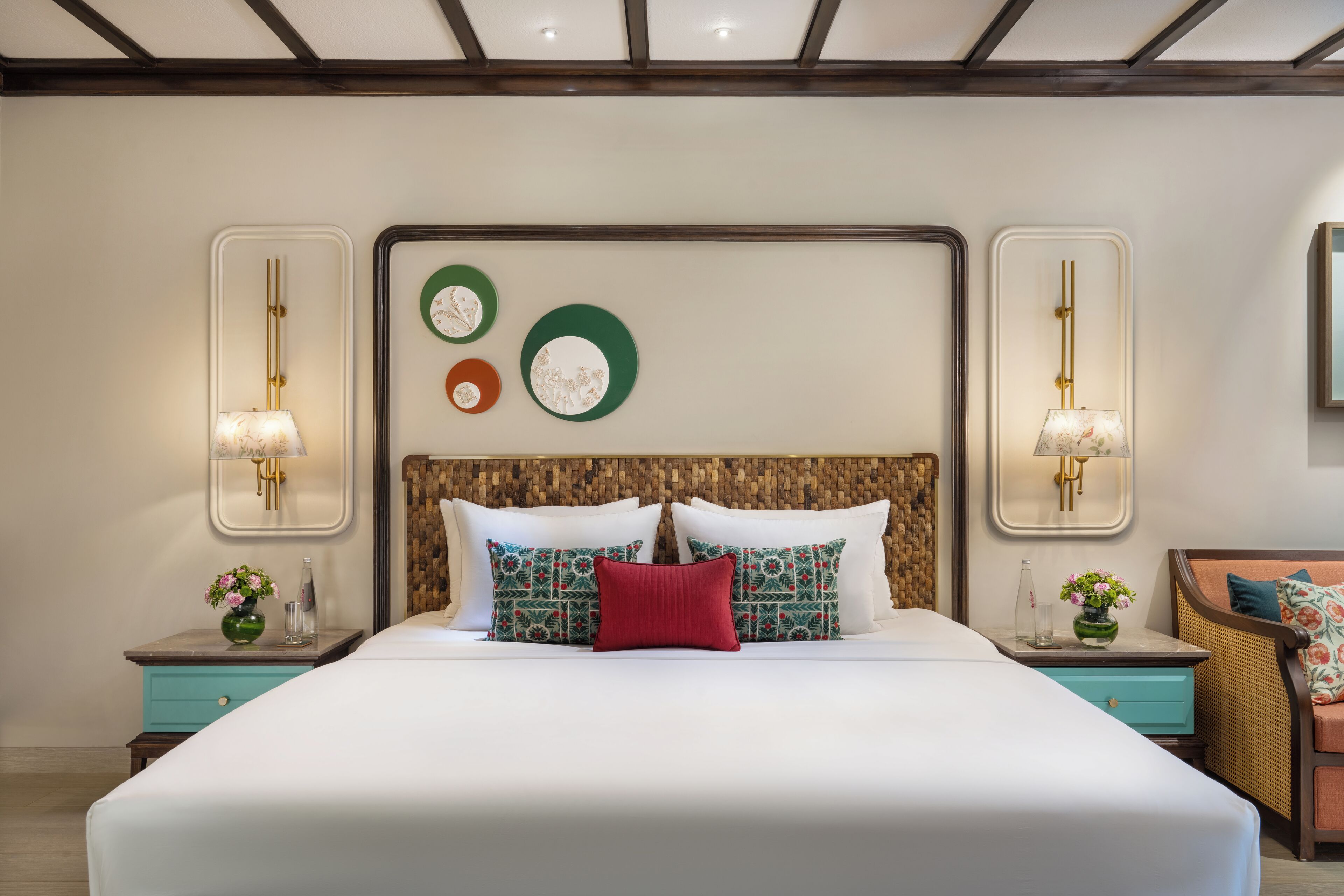 A neatly arranged hotel room with a large bed, two bedside tables with lamps, and decorative wall art.