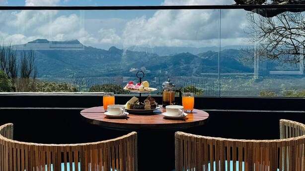 A table with breakfast items and a view of mountains. - Fountain, Mahabaleshwar - IHCL SeleQtions (Mahabaleshwar)