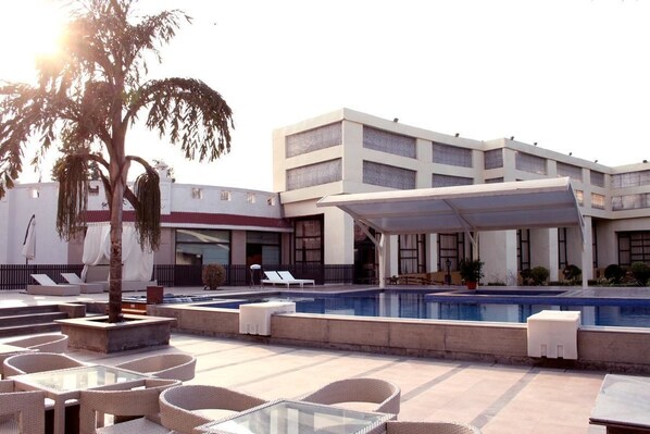 Outdoor pool, pool umbrellas, pool loungers - Hotel Clark Greens- Airport Hotel & Spa Resort (New Delhi)