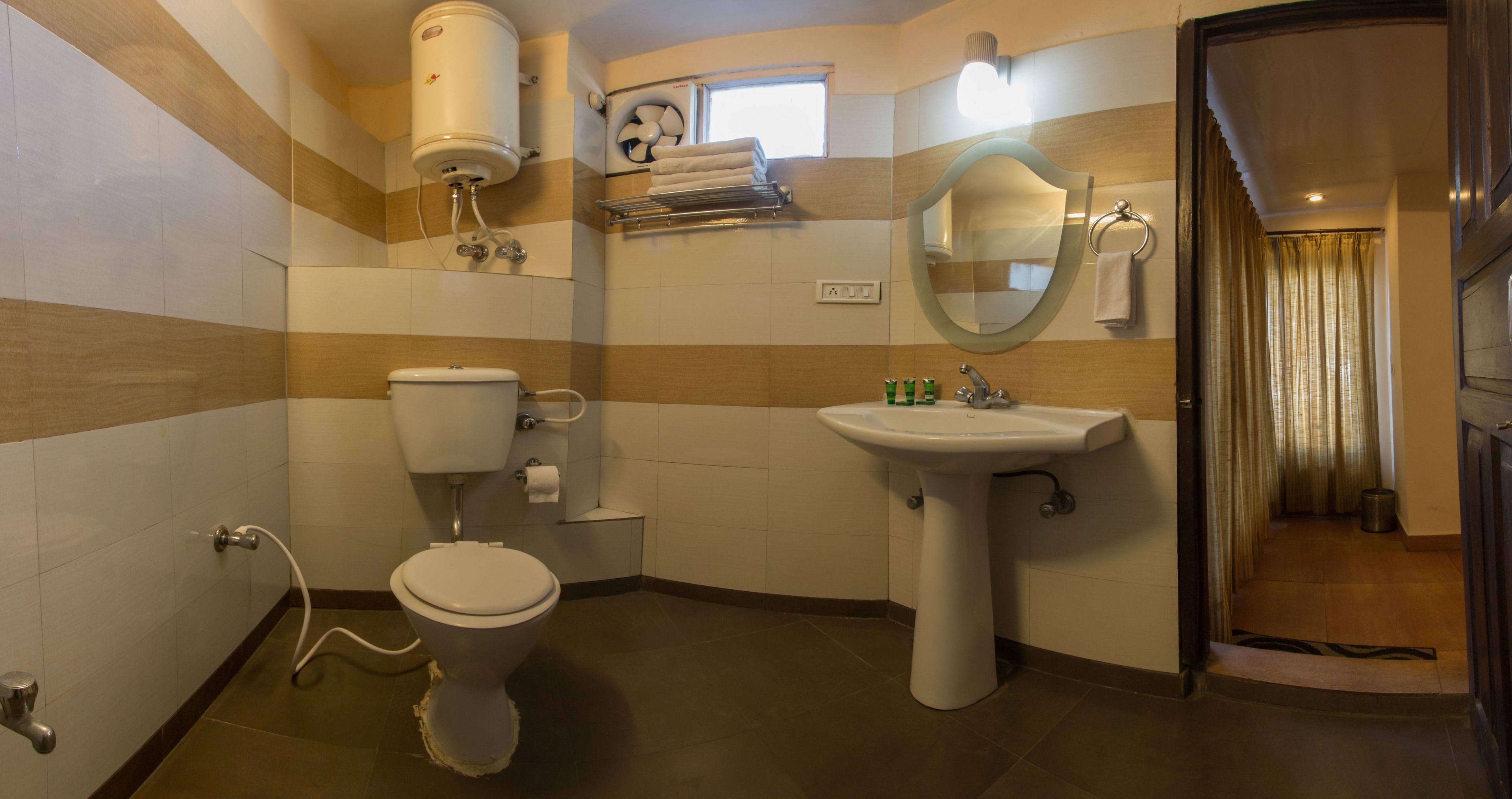 A bathroom with a toilet, sink, and shower area.