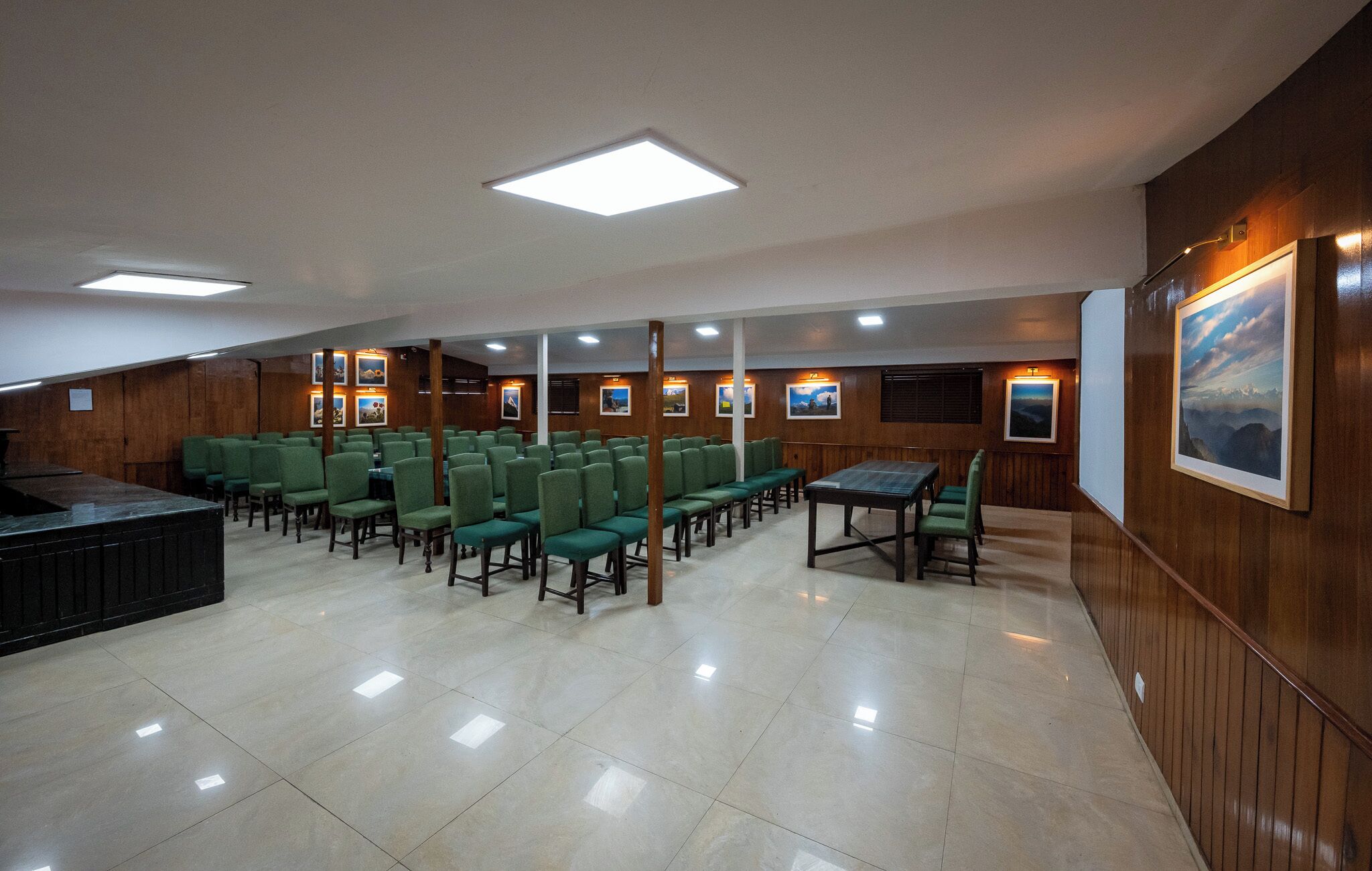 A conference room with green chairs, a table, and wooden paneling.