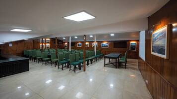 A conference room with green chairs, a table, and wooden paneling.