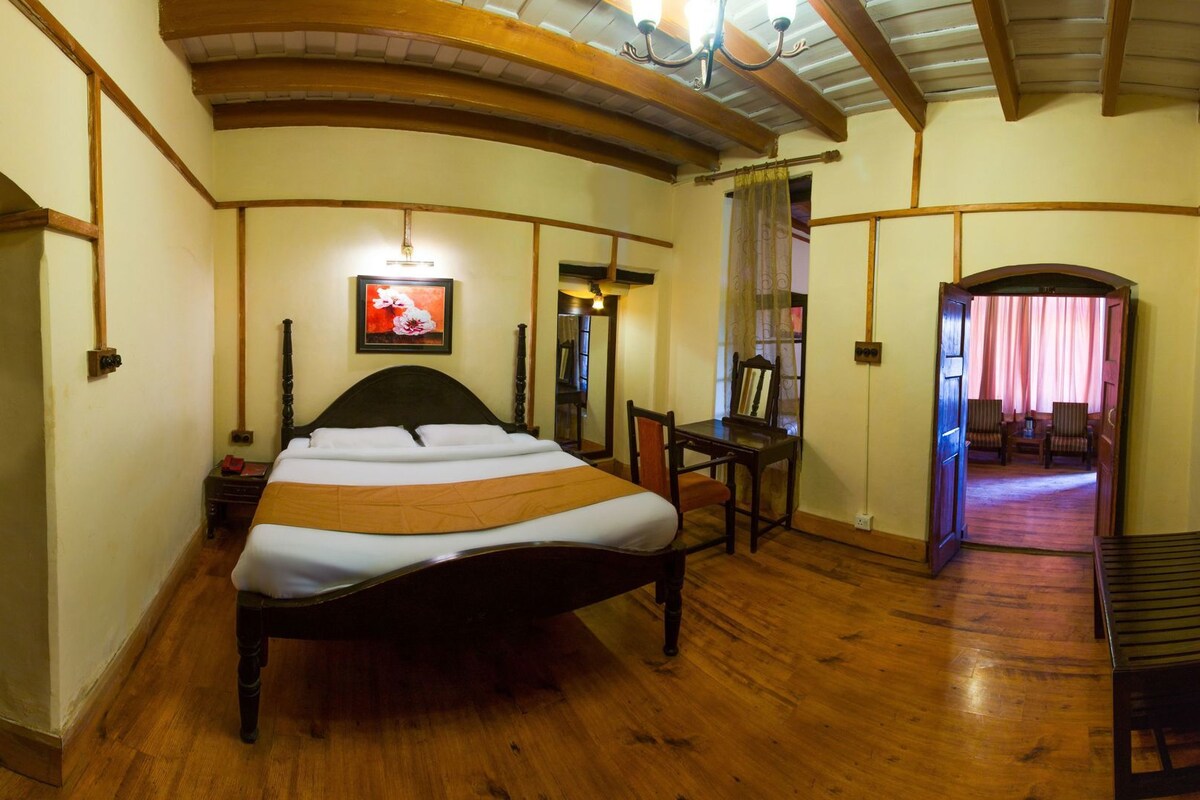 Una habitación con cama, escritorio, silla y espejo.