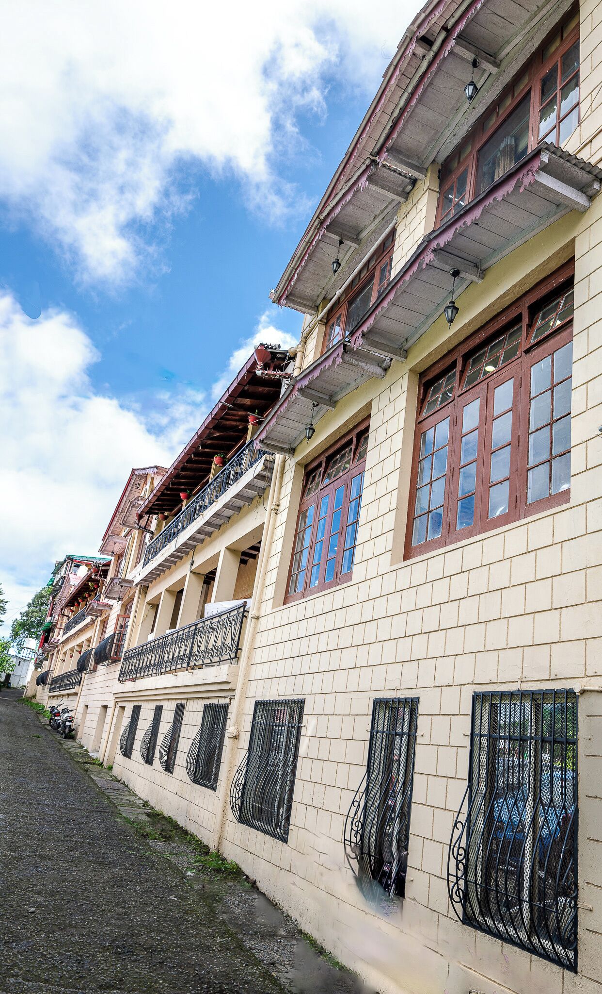 A row of traditional buildings with balconies, tiled walls, and metal window bars.