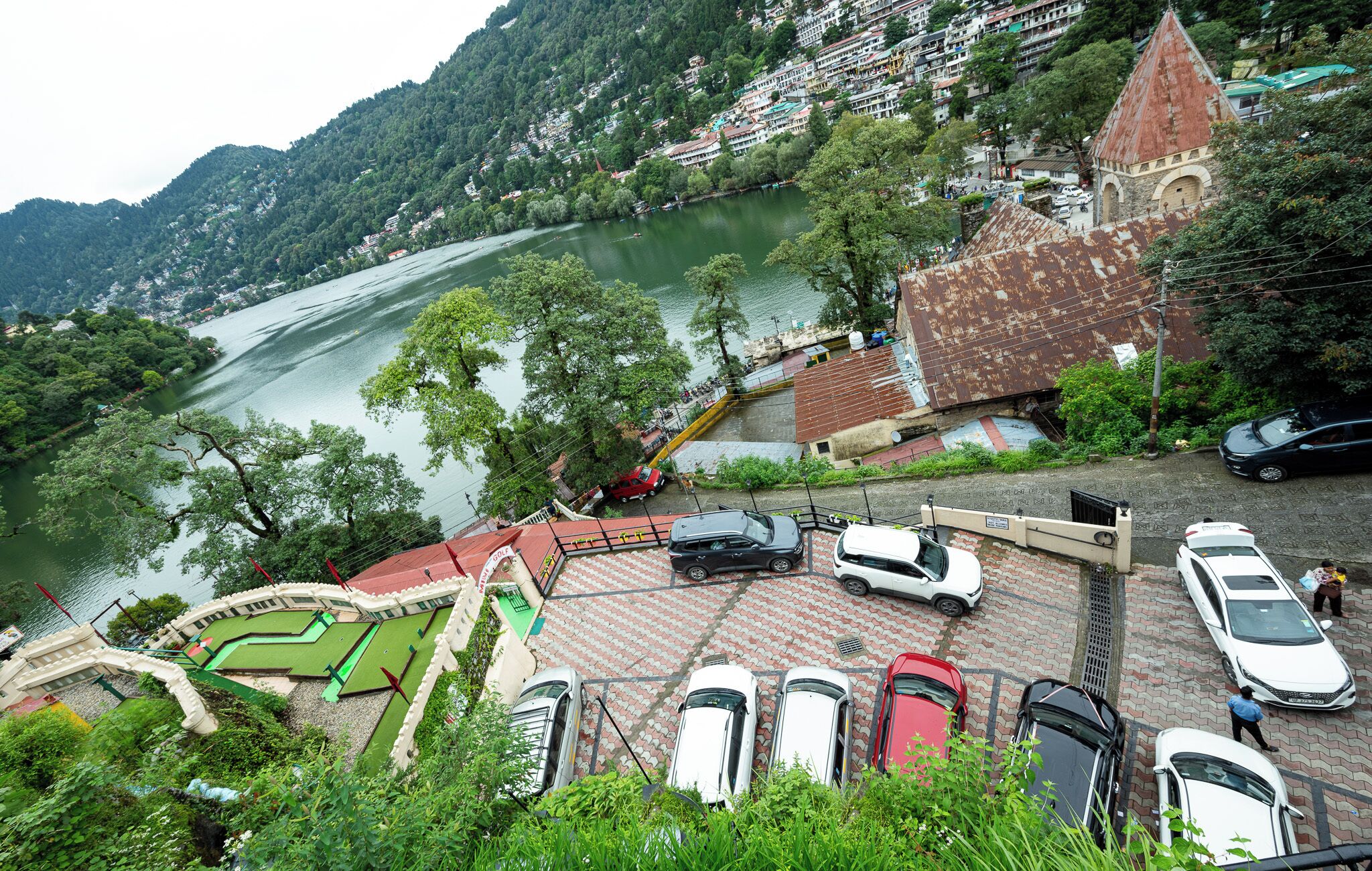 Aussicht auf einen Fluss mit Parkplatz, Kirche und Spielplatz.