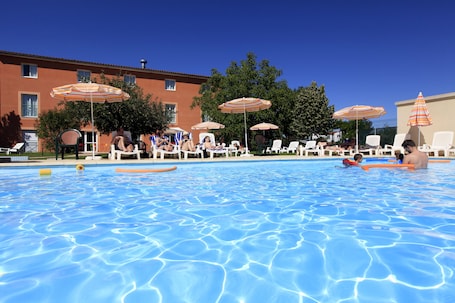 Una piscina al aire libre de temporada, sombrillas