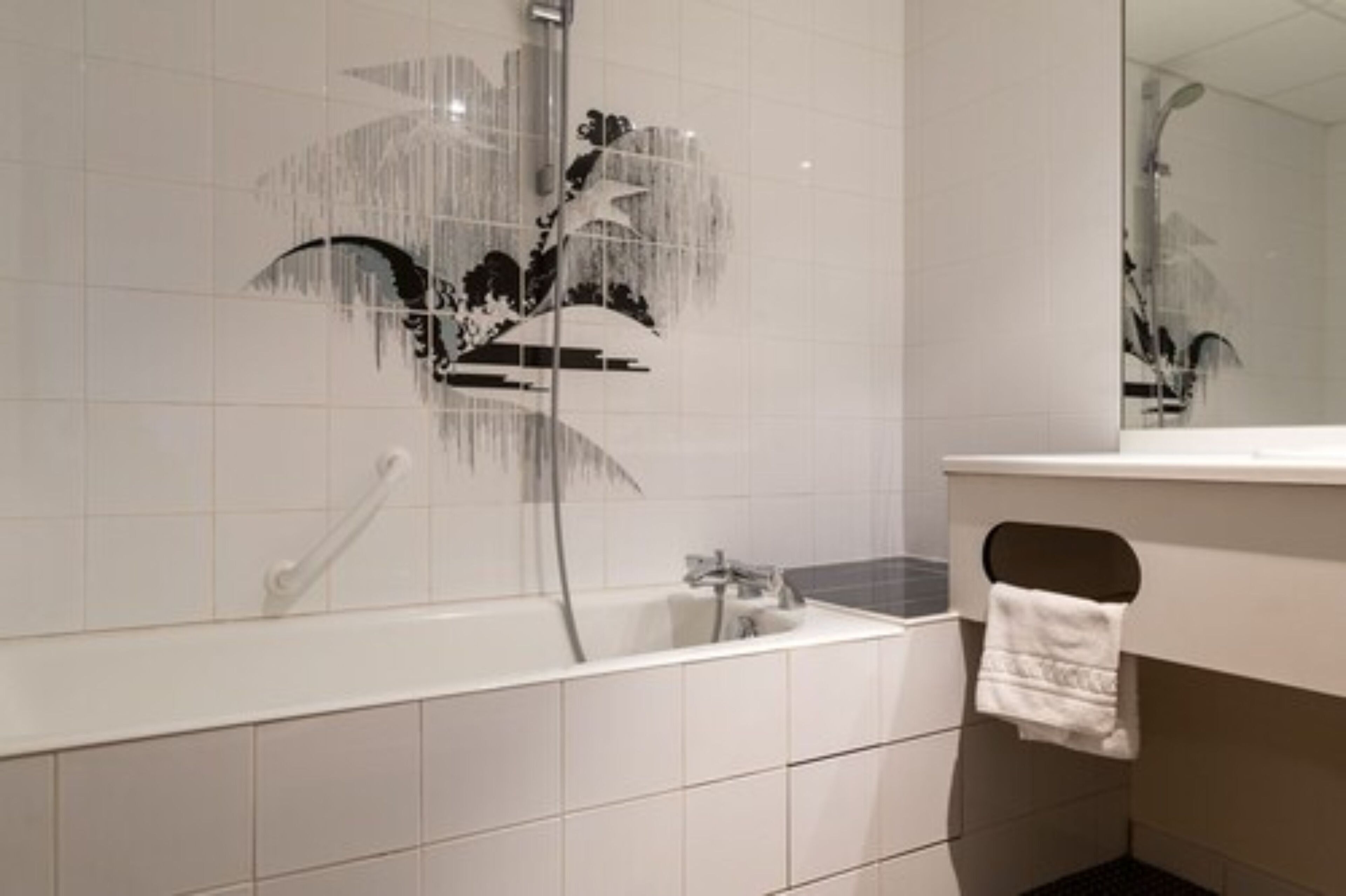 A modern bathroom with a bathtub, a shower, and a large mirror.