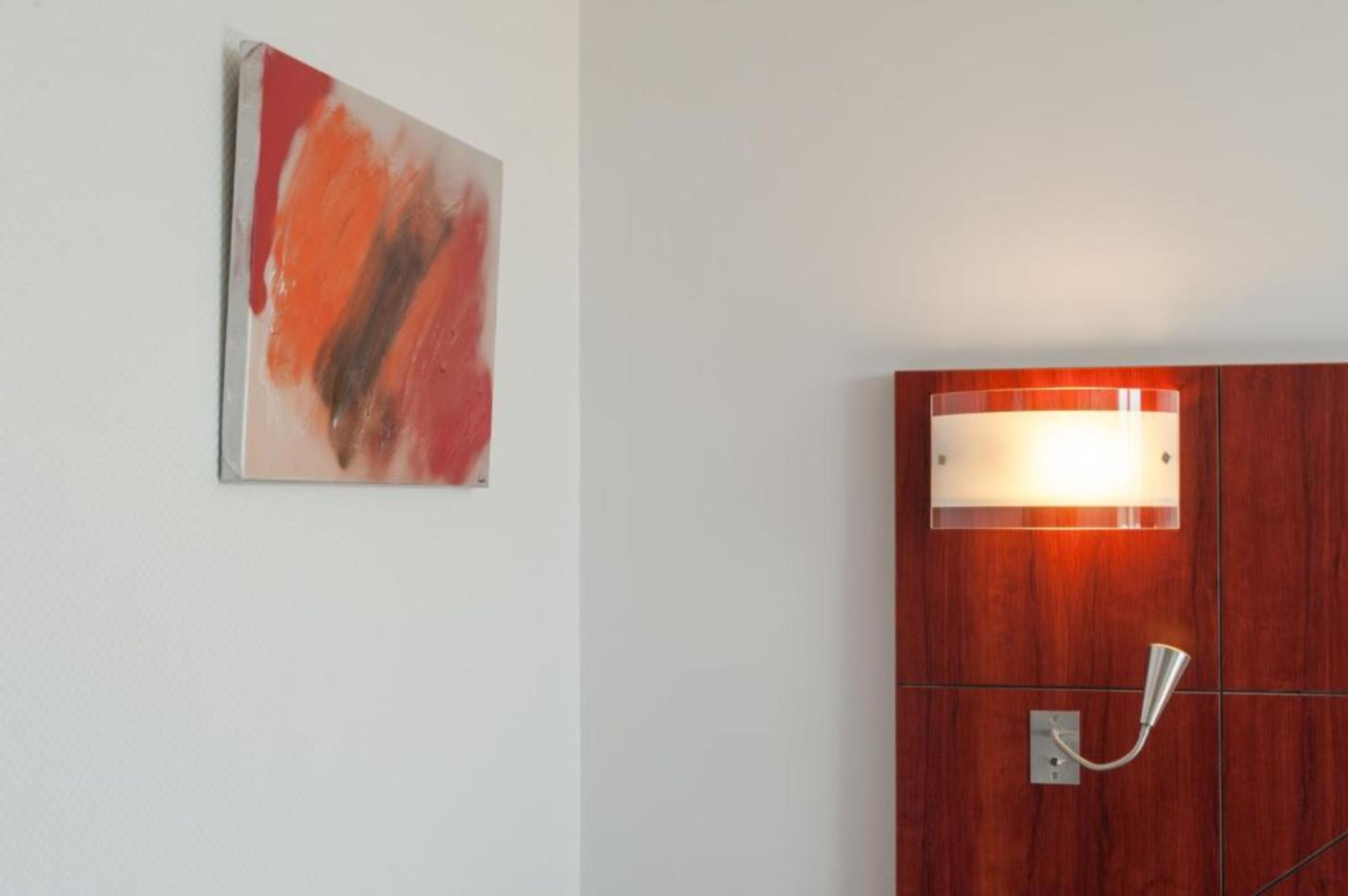 A room with a wooden cabinet and a wall-mounted light fixture.