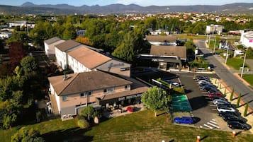 An aerial view of a hotel with a parking lot, a bar, and a pizzeria.