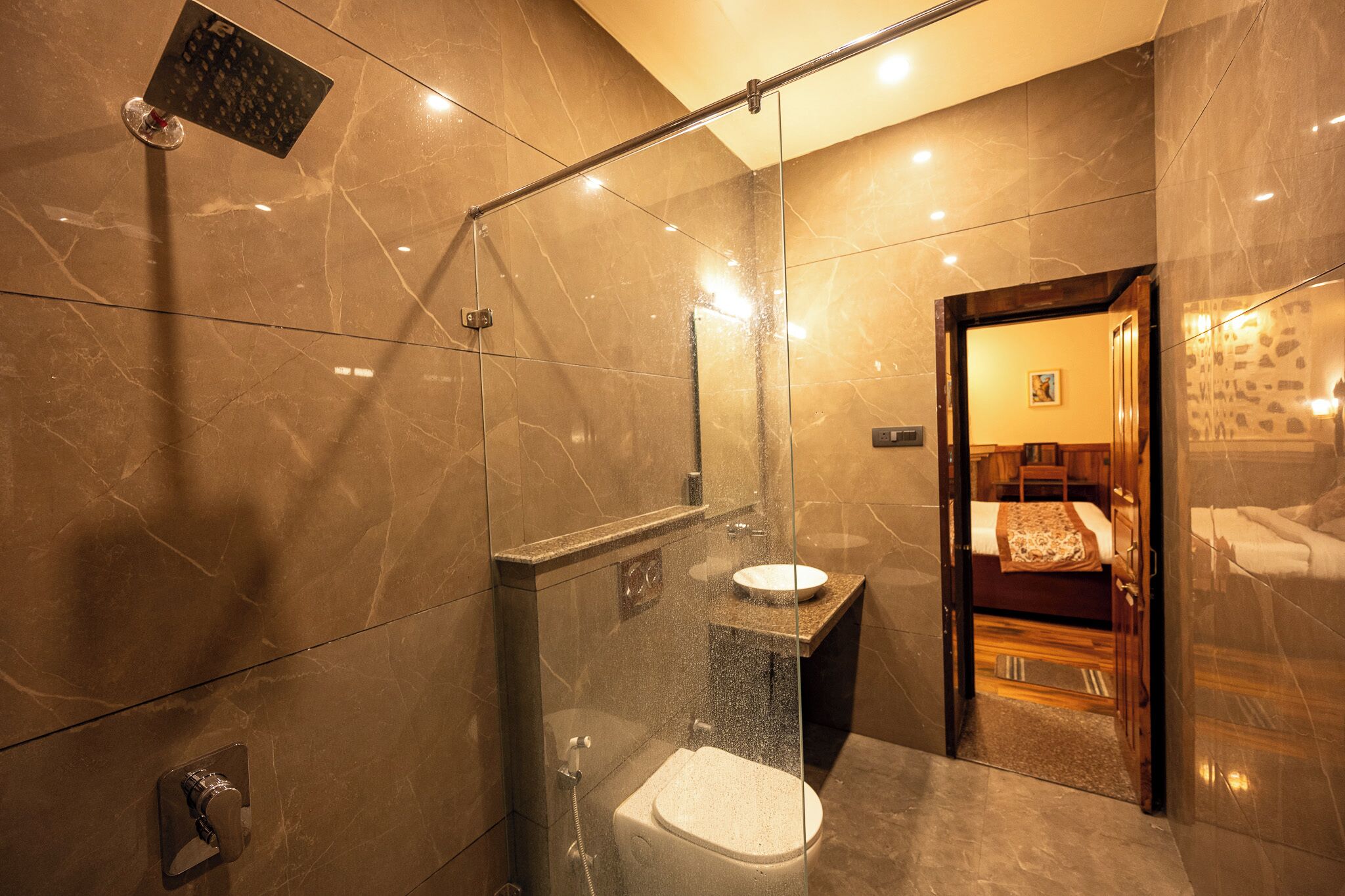 Ein modernes Badezimmer mit einer Dusche in Glasabtrennung, einer Toilette und einem Waschbecken.