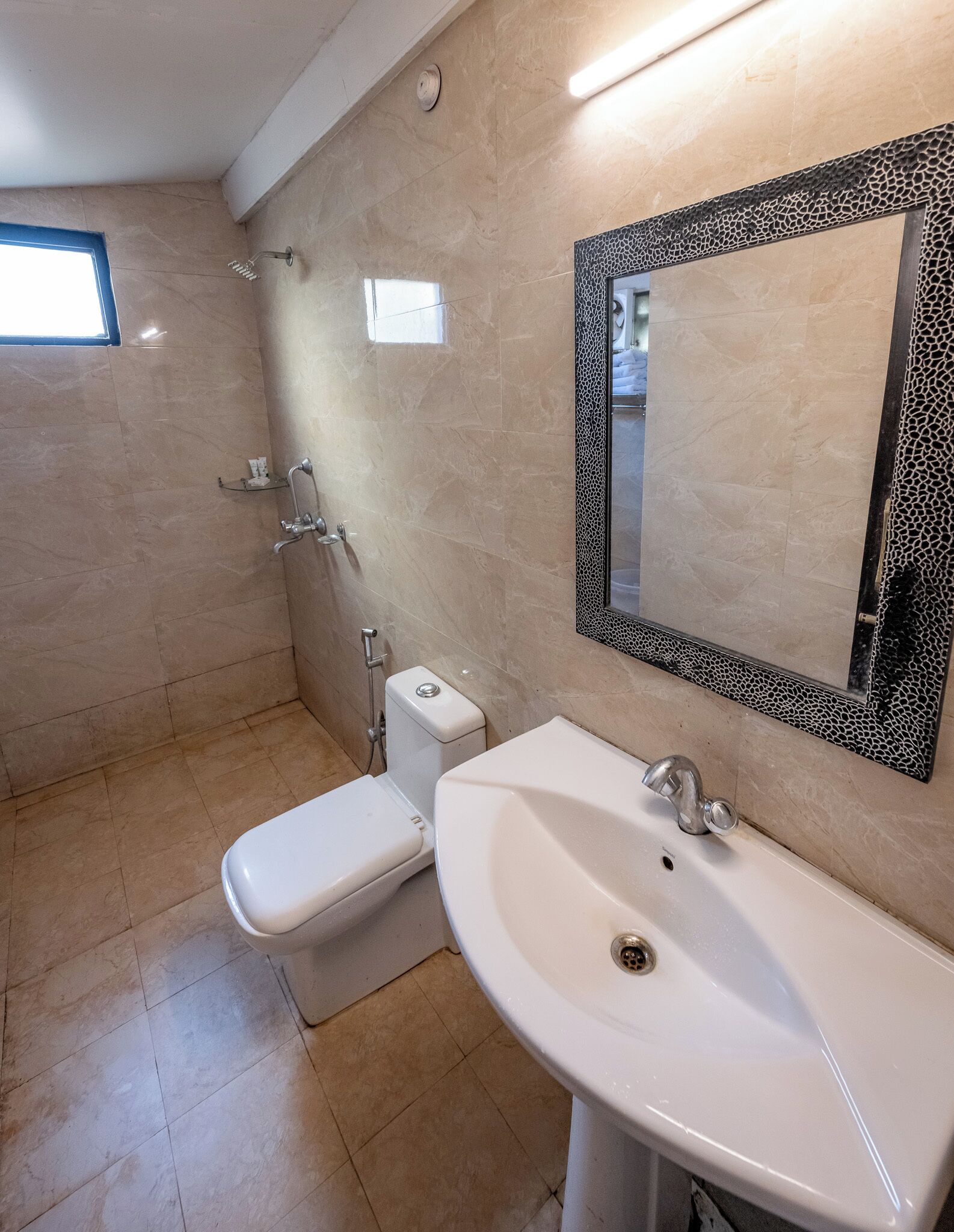 A bathroom with a toilet, bidet, and sink, all in white.