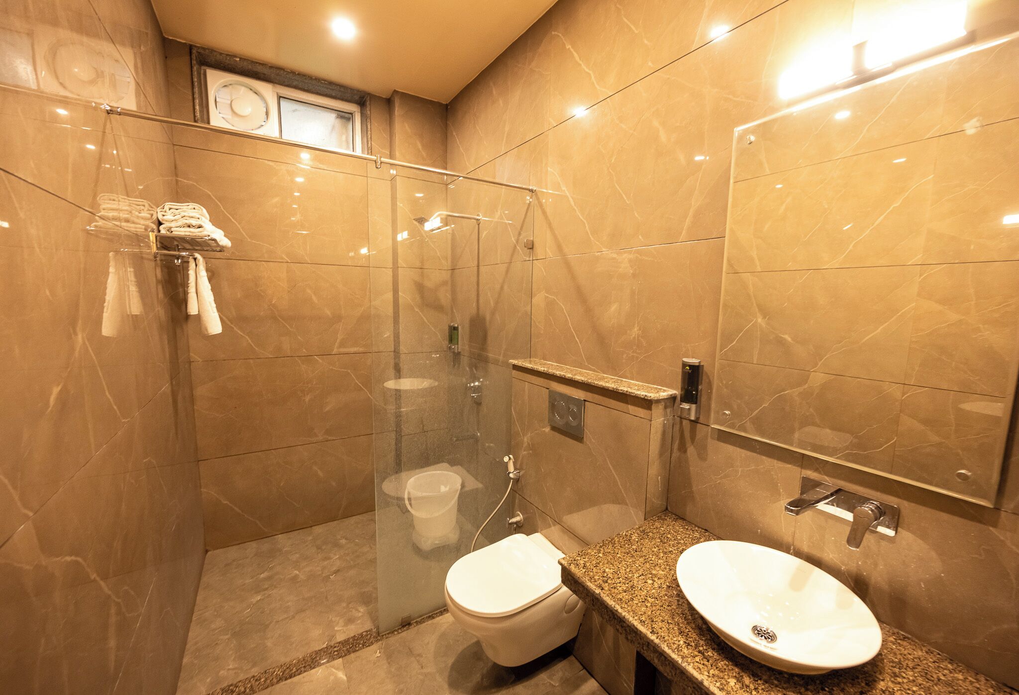 A modern bathroom with a glass-enclosed shower, a toilet, and a vanity with a sink.