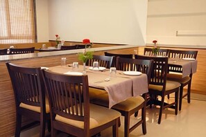 Enjoy meals in this stylish dining area with a long table, comfortable chairs, and elegant table settings.
