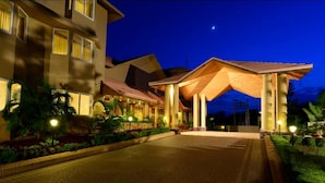 A hotel entrance with a covered walkway, a well-lit pathway, and a night sky. - The Chariot Resort & Spa (Puri)