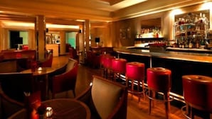 A bar area with wooden furniture and red bar stools. - The Chariot Resort & Spa (Puri)