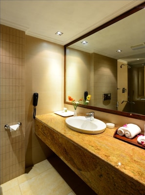 A hotel bathroom with a marble sink, a large mirror, and a towel rack. - The Chariot Resort & Spa (Puri)