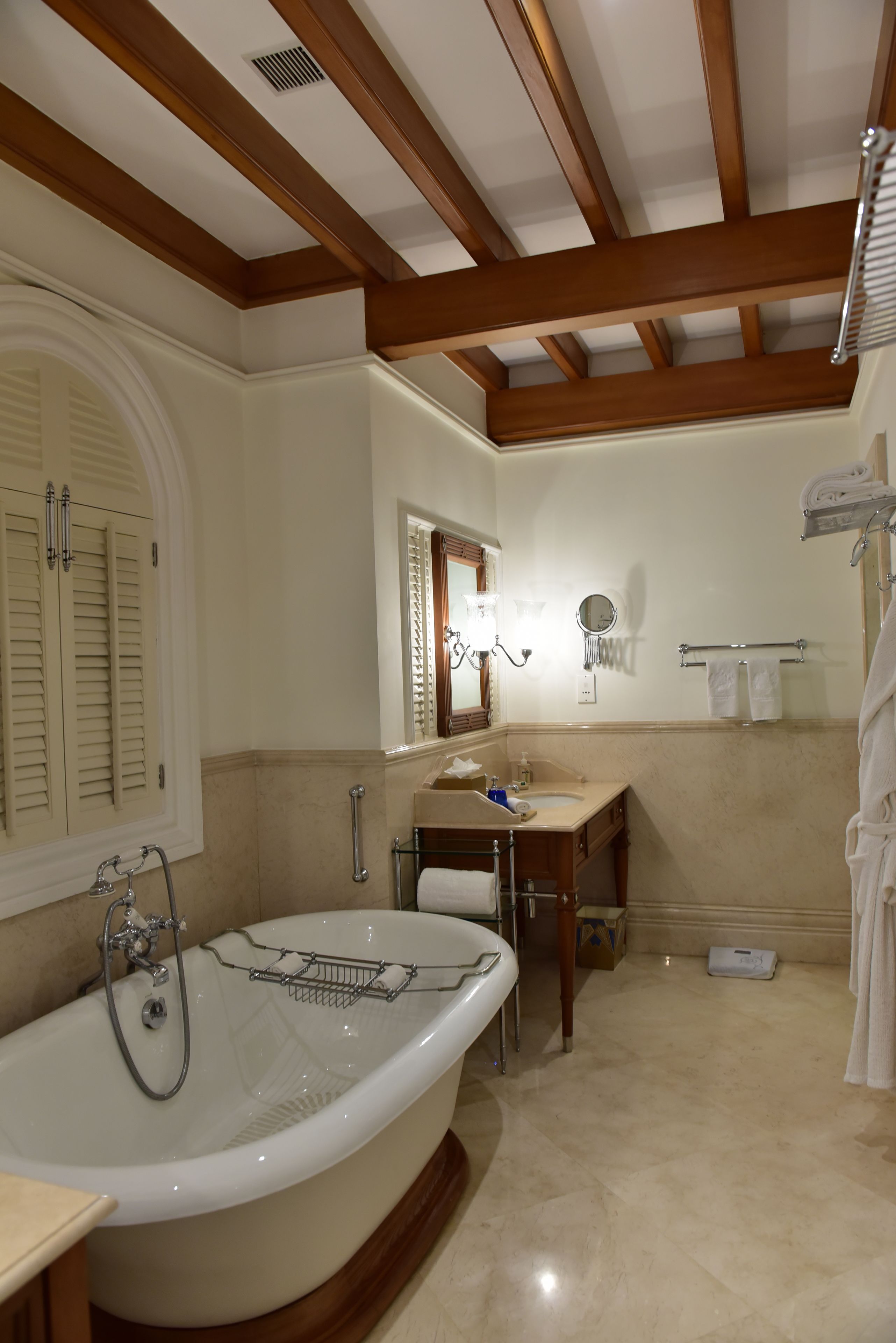 A bathroom with a freestanding bathtub, vanity, and a towel rack.